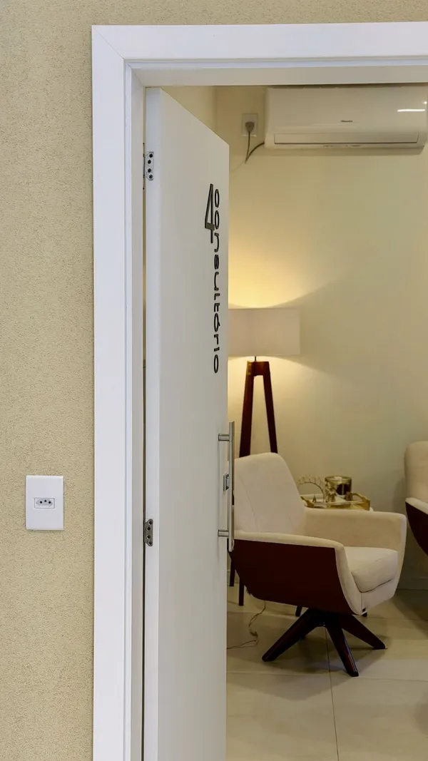 Porta do consultório da Dra. Franciele, oncologista em Santiago, RS, com a sala de espera ao fundo